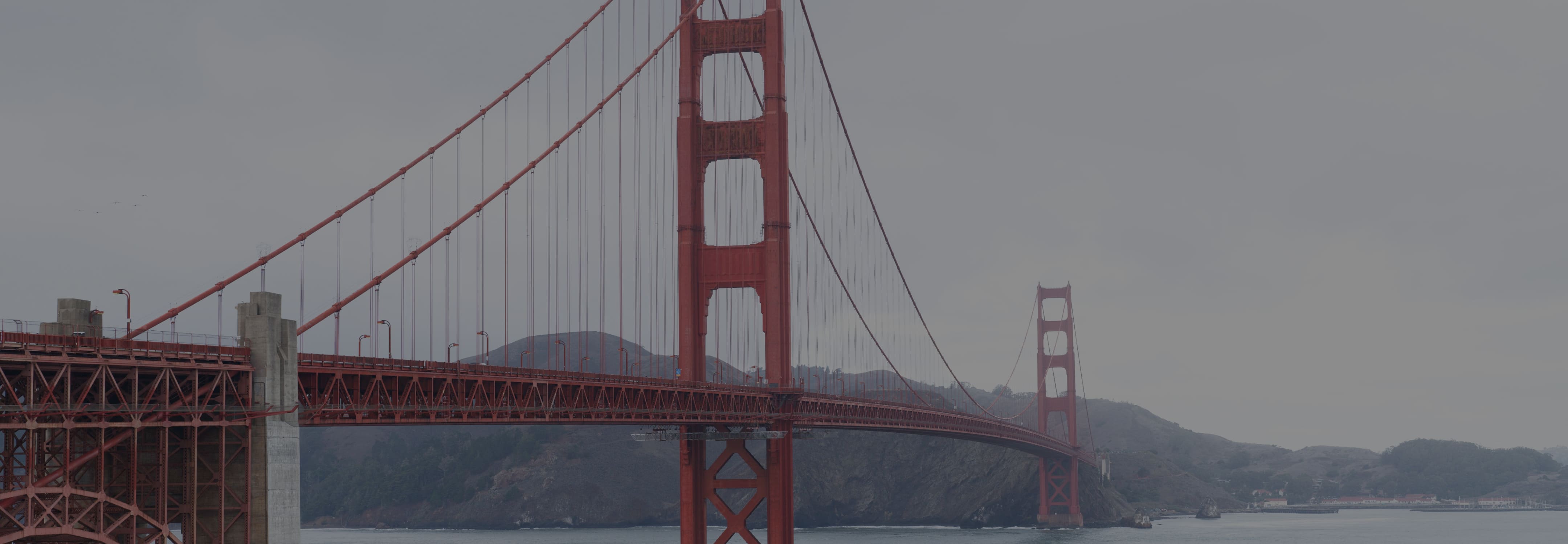 The Golden Gate Bridge spanning San Francisco Bay on a foggy day.