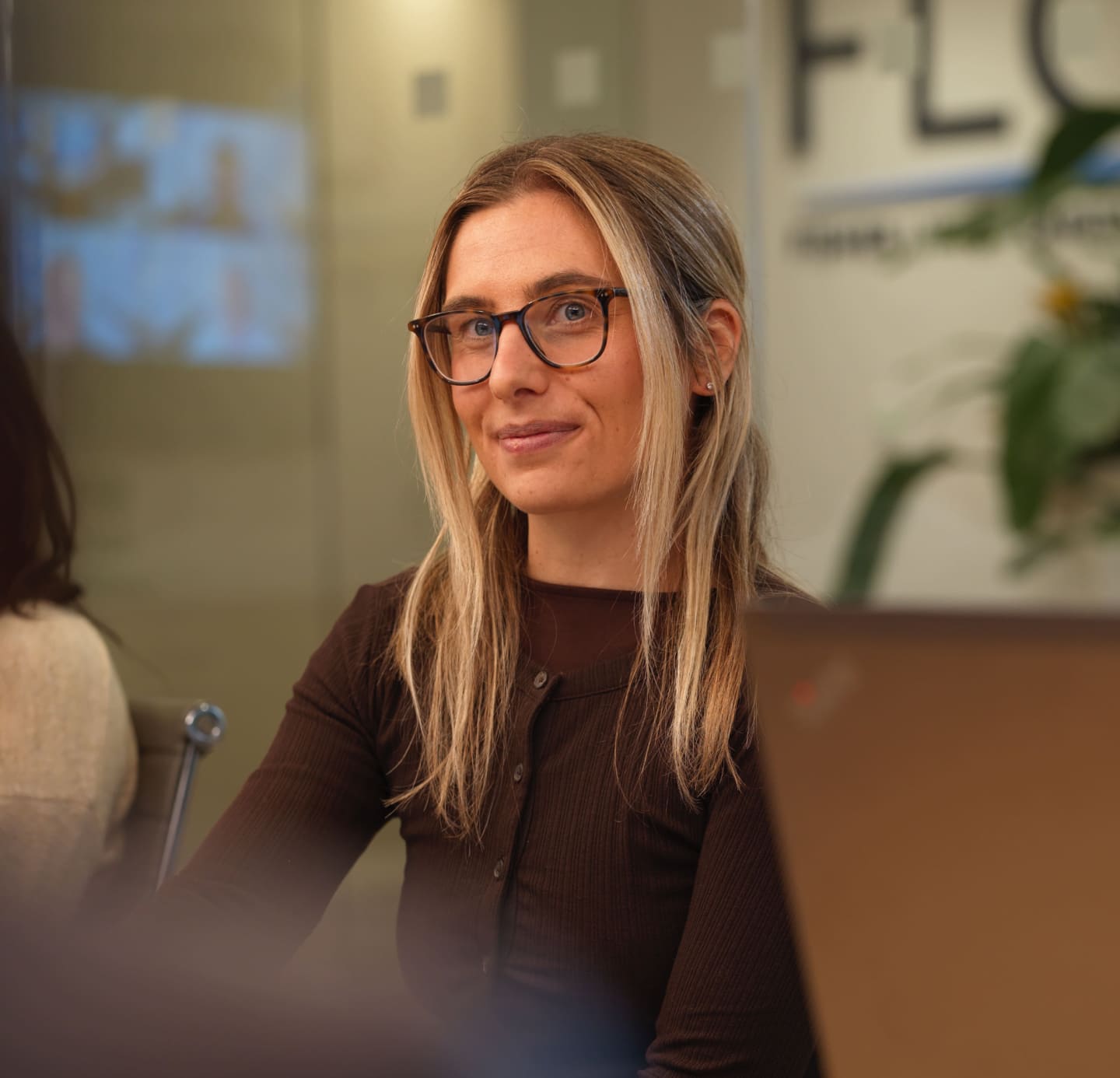 Portrait of a colleague wearing glasses during a meeting in a modern office.