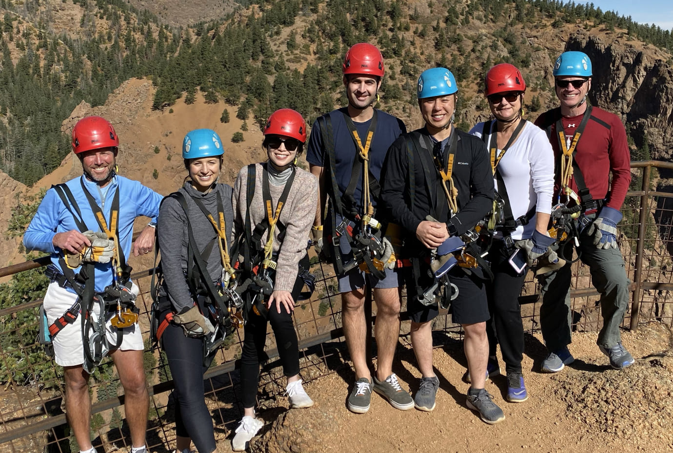 Fisher Lynch team members wearing helmets and safety harnesses during an outdoor adventure outing.