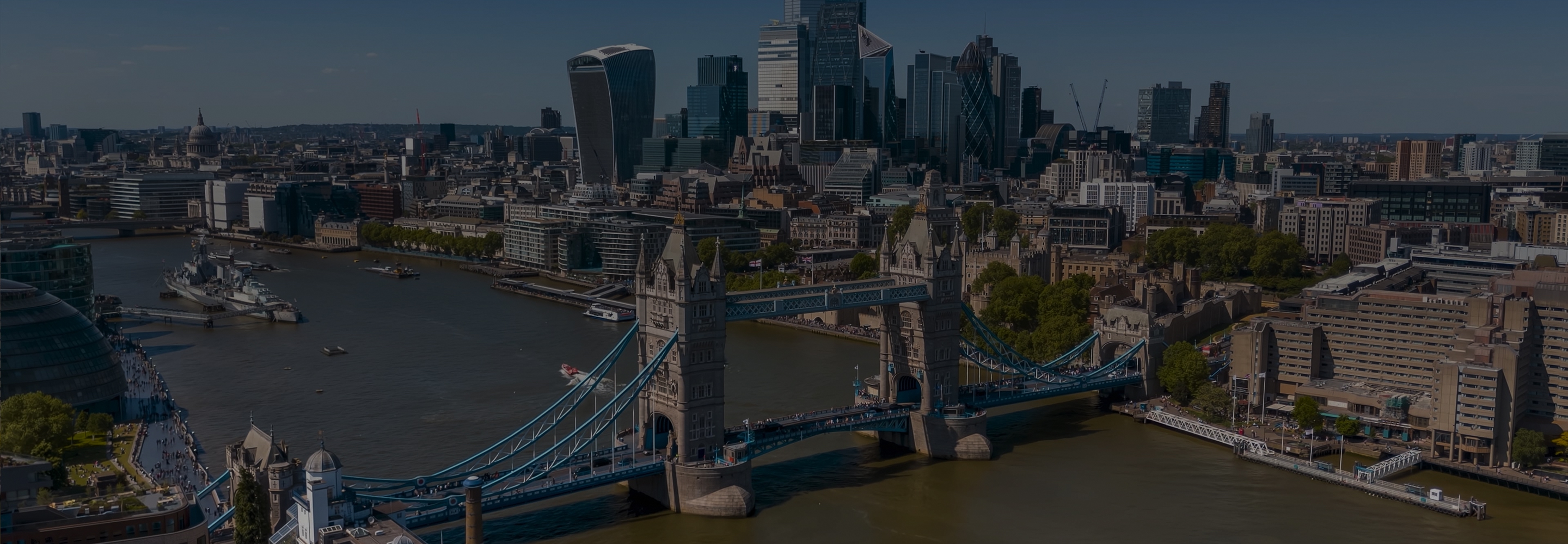 Aerial view of Tower Bridge over the River Thames with the City of London skyline in the background.